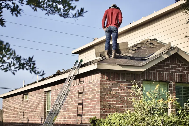 Professional roofer working on a residential roof in Ashton Pond